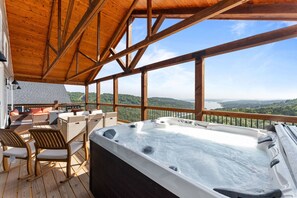 The back deck is expanded and includes hot tub, outdoor dining, rocking chairs, fire table, and Blackstone Griddle