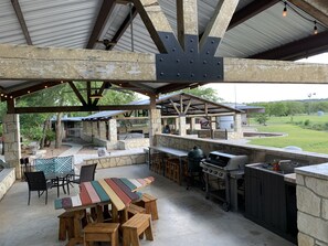 Outdoor kitchen, 6 burner weber, green egg and sink. Adjacent to pool and patio