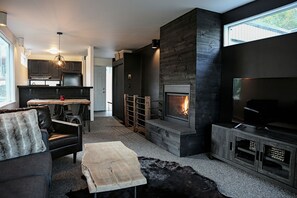 Upper level/Main living area of unit with living room with fireplace, dining table, and kitchen