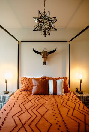 The queen-sized bed takes center stage, adorned with terracotta-colored blankets