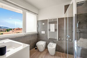 The bathroom with shower, toilet and bidet