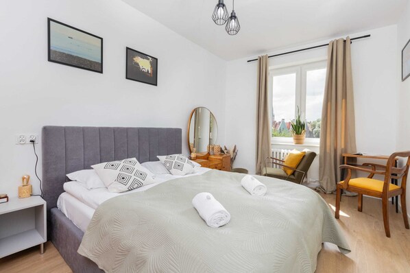 A bright bedroom featuring a comfortable double bed with fresh linens and natural light streaming through the window.