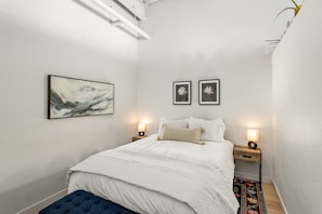 Guest bedroom (right wall is open-air to living room) with queen-sized bed and closet