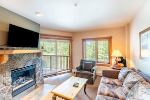 Cozy living area with mounted flat screen TV, gas fireplace and access to the private balcony.
