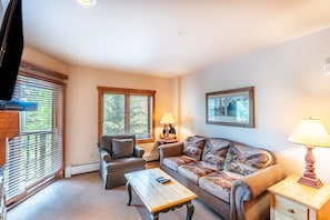 Cozy living area with mounted flat screen TV, gas fireplace and access to the private balcony.