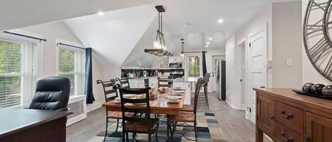 Large space and table comfortably sits six with extra dining room in kitchen island. Artistic early 1900s original toll house next door was lifted 100 feet to its current position, viewed through the windows.