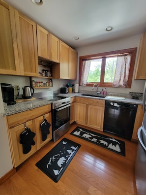 Thoughtfully stocked kitchen with spices, new knives and cooking utencils.