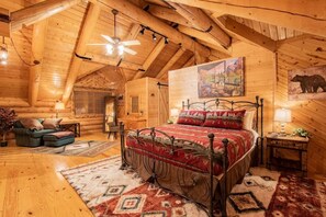 The open plan loft is furnished with a cal-king bed, a futon, seating couch, and desk. It features a private bathroom and walk-in closet.