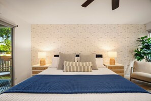 Kind bed flanked by 2 bedside tables, roller shades provide blackout privacy. 