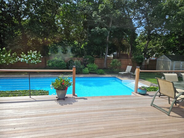 brand new backyard deck with solar heated saltwater pool in fenced in yard