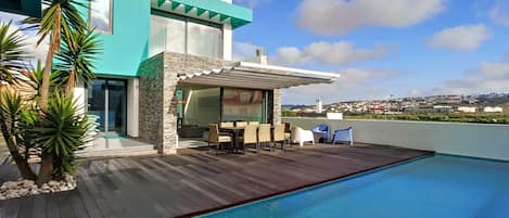 Backside of the house: pool, deck, dinner table, lounge area