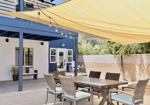 Shared courtyard with dining area, lights and shade tarp