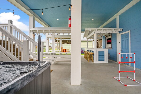 A hot tub, large games, tiki bar, tv, and plenty of seating adds more fun.