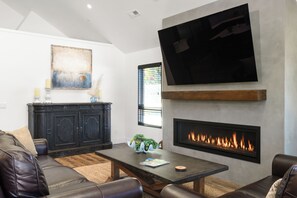 Living room with gas fireplace and big screen LG OLED TV