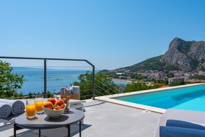 a sun deck area with 6 decks chairs overviewing town Omiš, sea and mountains
