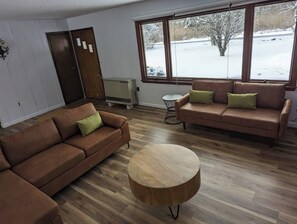 The living room has an oversized window watching the quiet front yard