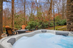 Enjoy our eight-person hot tub with a great view of the woods behind our home.