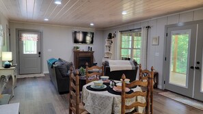 Living and dining area with double doors out to screened porch