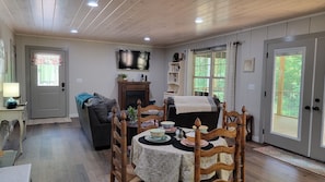 Living and dining area with double doors out to screened porch