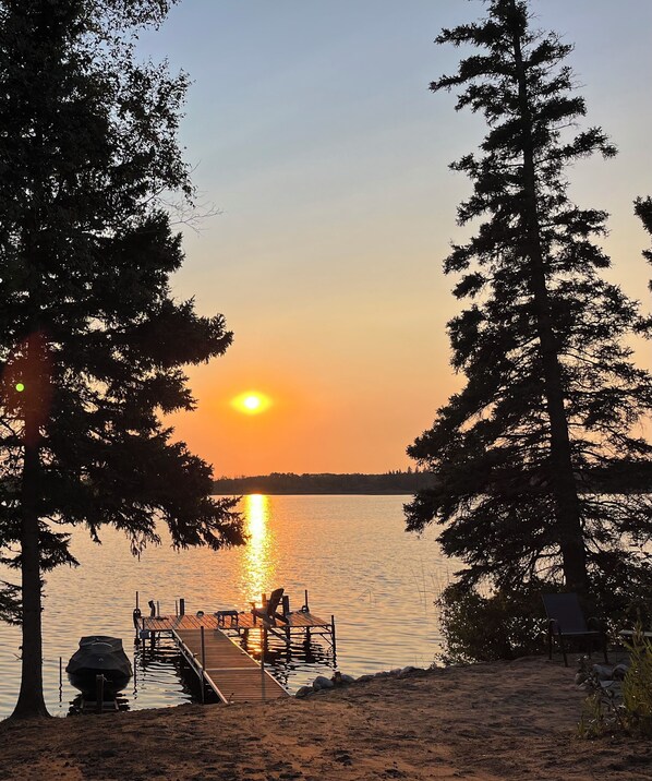 Watch the beautiful sunset from the private sand beach and dock.