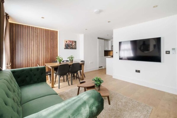 Luxury living room with wood panels, LED lights, 65" Smart TV & air conditioning