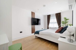 Bedroom with king-size bed, 55" Smart LED TV, and air conditioning for comfort.