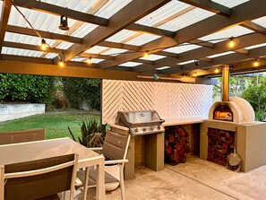Garden entertainment area with woodfired pizza oven, barbecue & festoon lighting