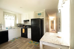Kitchen with Refrigerator, Microwave, Dishwasher, Plates, Cups, Cookware