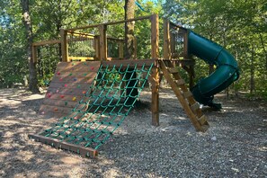 Adventure playset with rope net, slide, and ladder for endless outdoor fun.