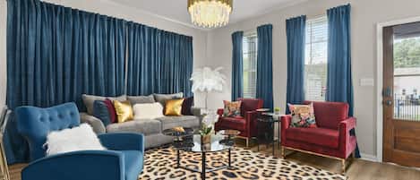 Elegant allure: Blue curtains and chandelier grace our elite living room