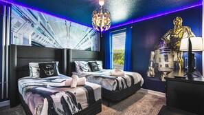 Epic galaxy-themed room with twin beds, cool lighting, star decor and movie vibe
