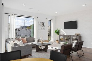 Spacious, comfortable living room with a Smart TV, open floor plan leading to the kitchen & dining area, and plenty of natural light.