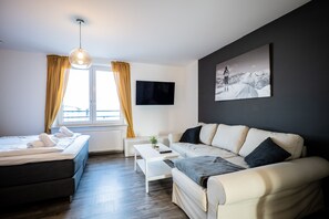 Ecksofa mit Couchtisch und Smart TV im Schlafzimmer