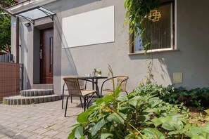 The building entrance, surrounded by lush greenery, providing a welcoming atmosphere.

