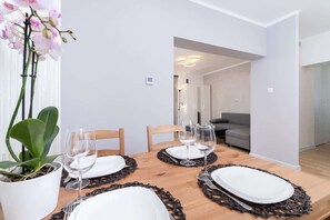 A dining table set with elegant plates and an orchid centerpiece, ideal for hosting meals.

