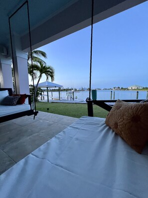 Twin bed swings overlooking deep blue water canal.