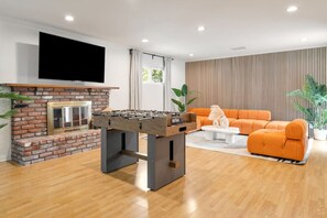 Spacious living area with a wide-screen smart TV and foosball to entertain guests