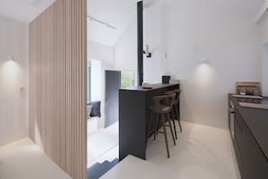 Double height space over two levels, the compact kitchen with breakfast bar