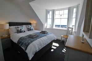 The bedroom is filled with natural light. The second double bedroom is on the upper level