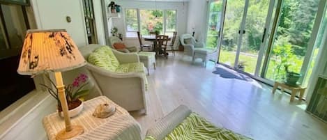 Sunporch overlooks sunny open back yard and garden. 
