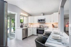 Large, modern kitchen all newly renovated with stainless appliances and views of the pool & backyard