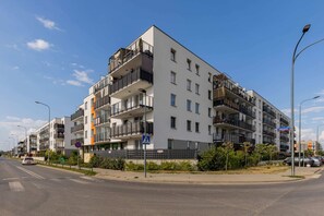 An exterior view of a modern apartment building with clean lines and landscaped surroundings.