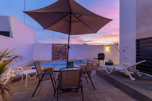 Experience the magic of a breathtaking sunset by the pool while relaxing in the cozy sitting area.