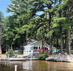 Cottage view from water with private dock, deck and fire pit. 