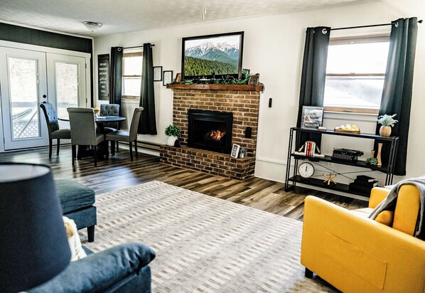 Cozy living room with a fireplace, bright decor, and a welcoming ambiance.