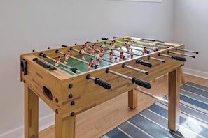 Family room equipped with 75" Smart TV, large leather couch, cozy LED fireplace, and foosball table! make this better.