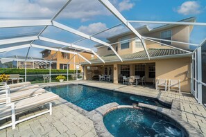 View of the back of home from the pool deck showing the covered lanai and seating