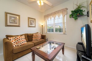 Sitting room just off the entry with a sofa and TV.