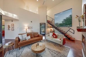 Beautiful living room with 25-ft ceilings, fireplace, and smart TV