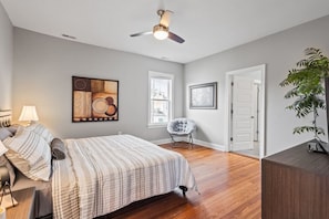 Master bedroom with dresser storage space, flat-screen Roku TV, King-sized bed, ceiling fan and full ensuite bathroom.